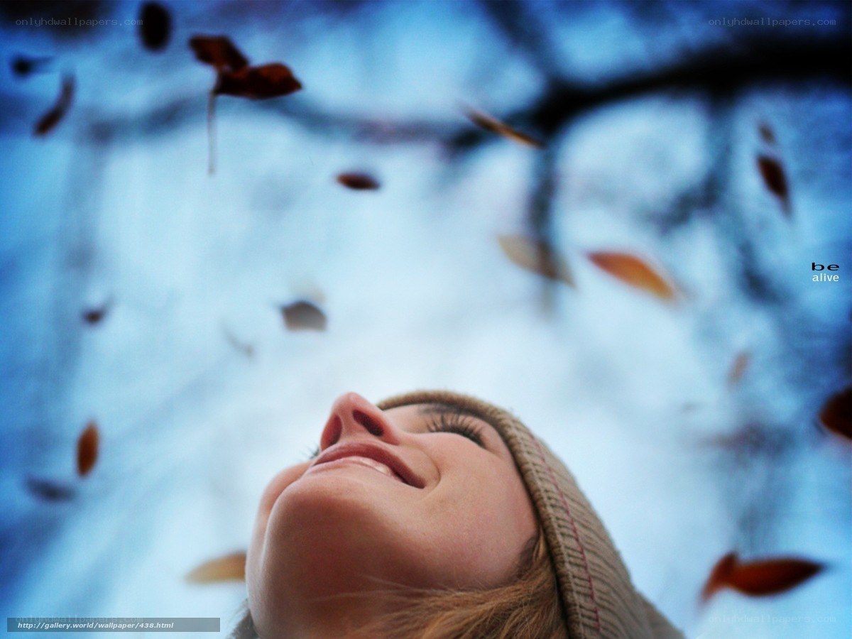 woman enjoying falling leaves