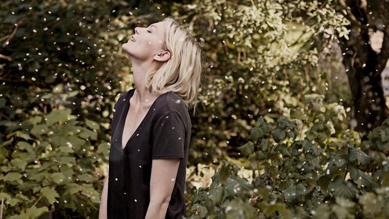 woman enjoying petals in garden