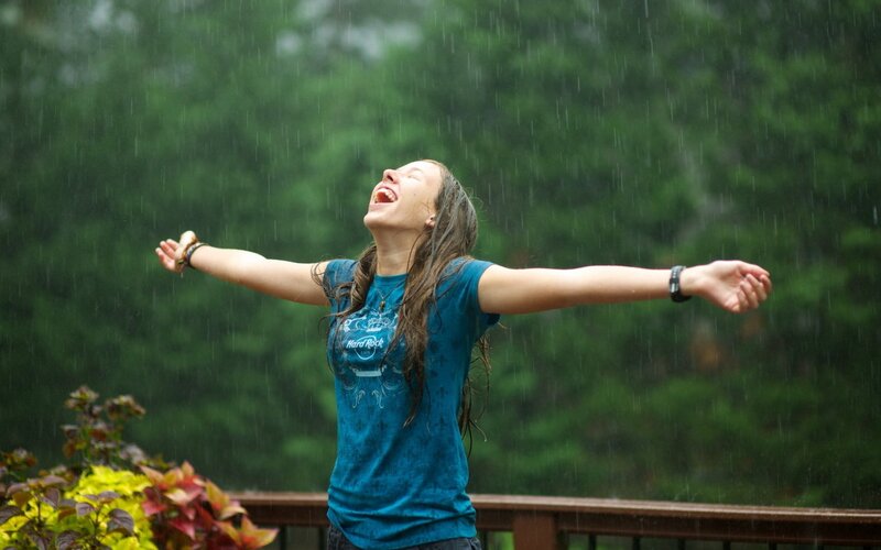 woman enjoying rain outdoors