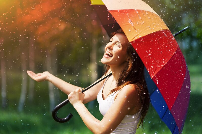 Woman enjoying rain under umbrella