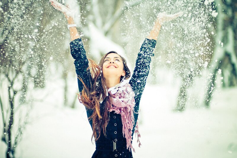 woman enjoying snowfall outdoors
