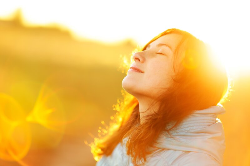 woman enjoying sun at sunset