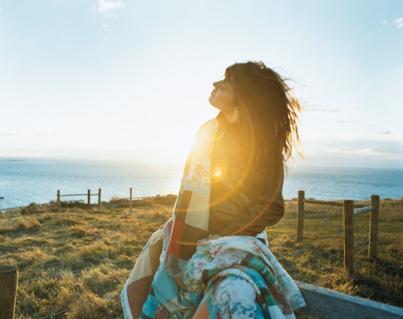 Woman enjoying sunset by the sea