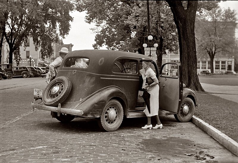 Woman exiting vintage car
