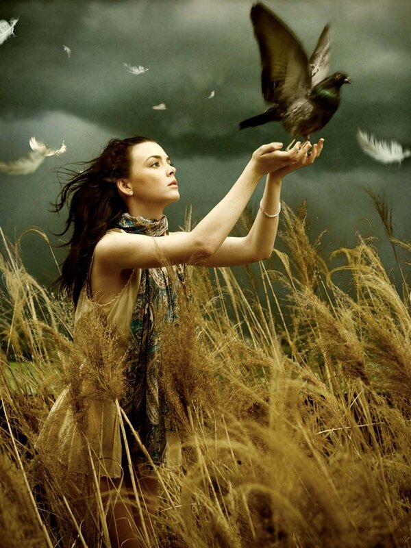 woman feeding a bird in field