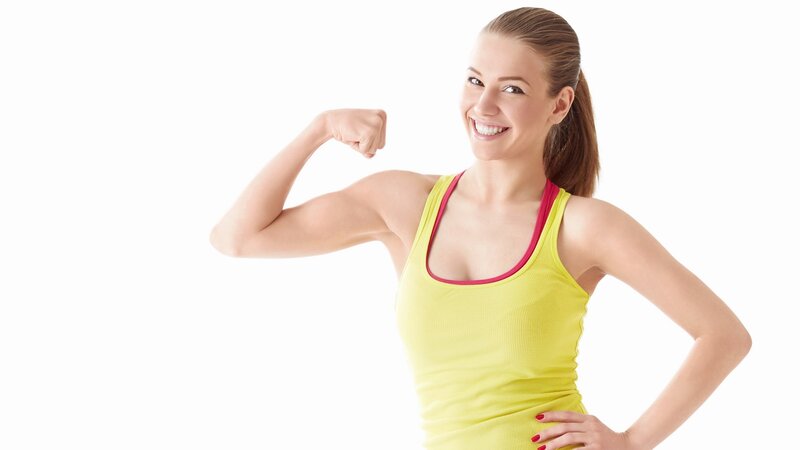 woman flexing arm in yellow top