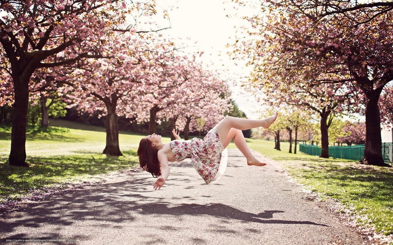 Woman floating in cherry blossom park