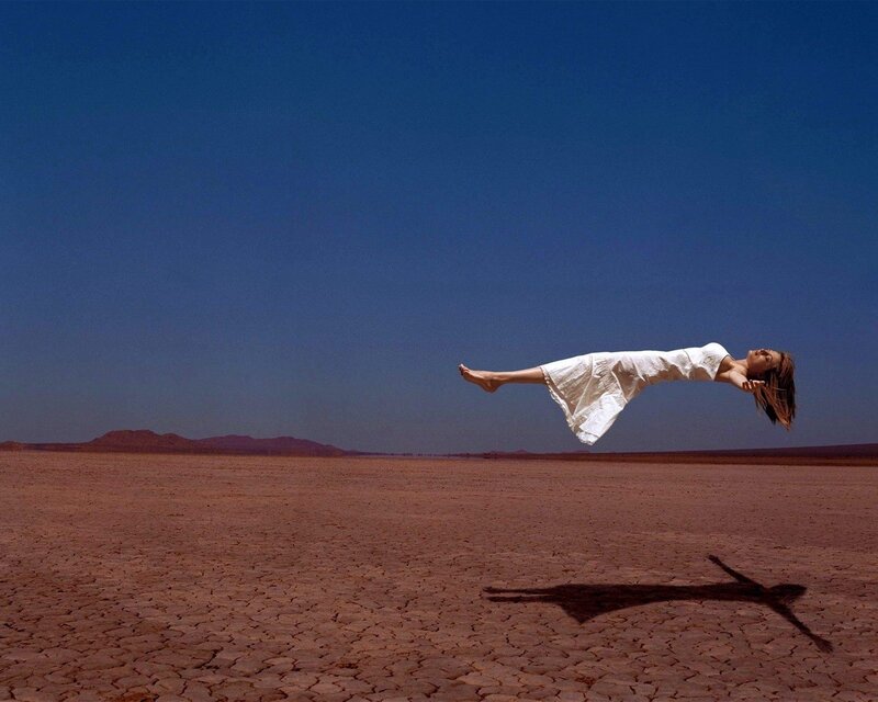 Woman Floating in Desert — Blue, Dramatic, Afternoon, Photograph, Sky, Mountains