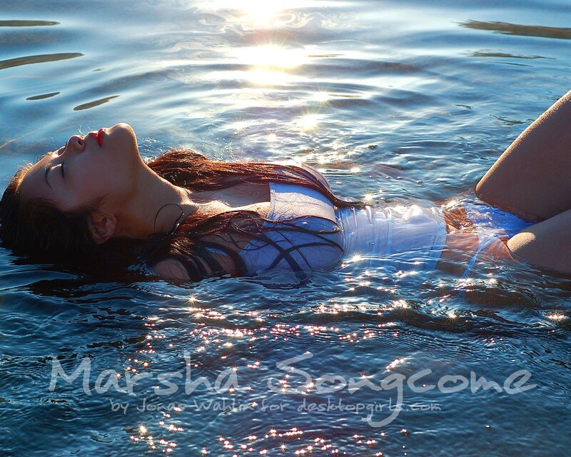 woman floating in water at sunset