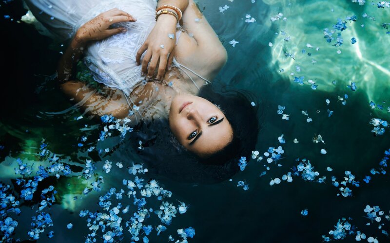 Woman Floating in Water — Blue, Serene, Photograph, Flowers