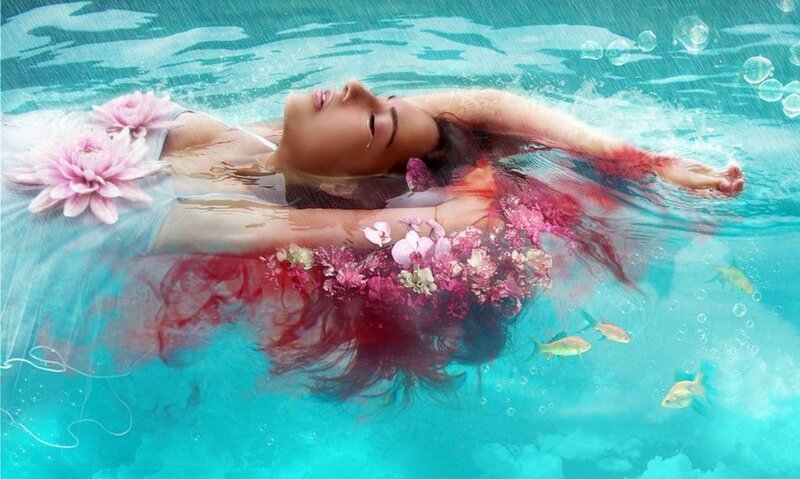 woman floating in water with flowers