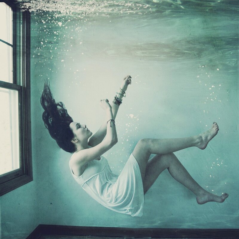 woman floating underwater in a room