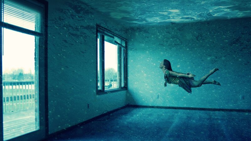 woman floating underwater in room
