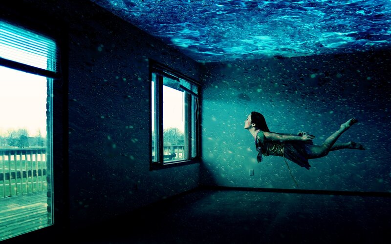 woman floating underwater in room