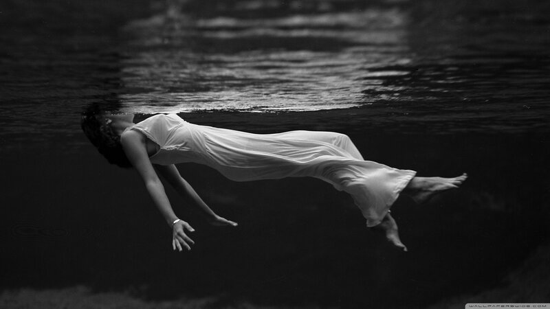 woman floating underwater in white dress