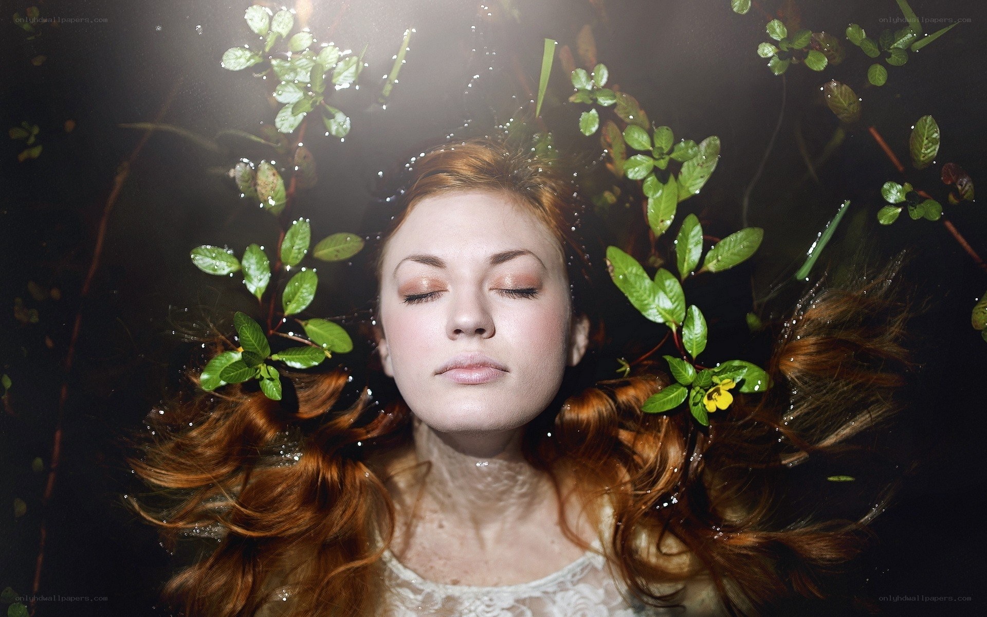 woman floating underwater with plants