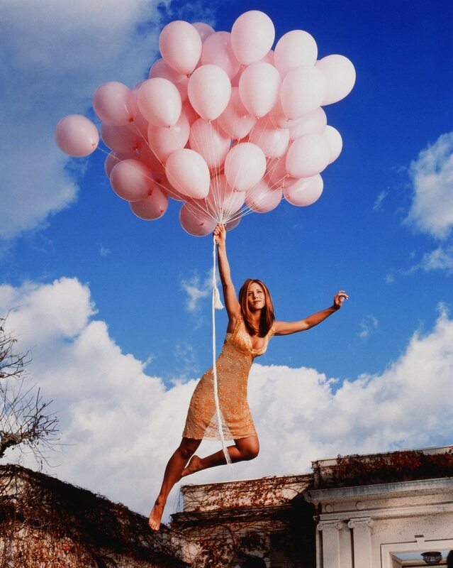 Woman floating with balloons