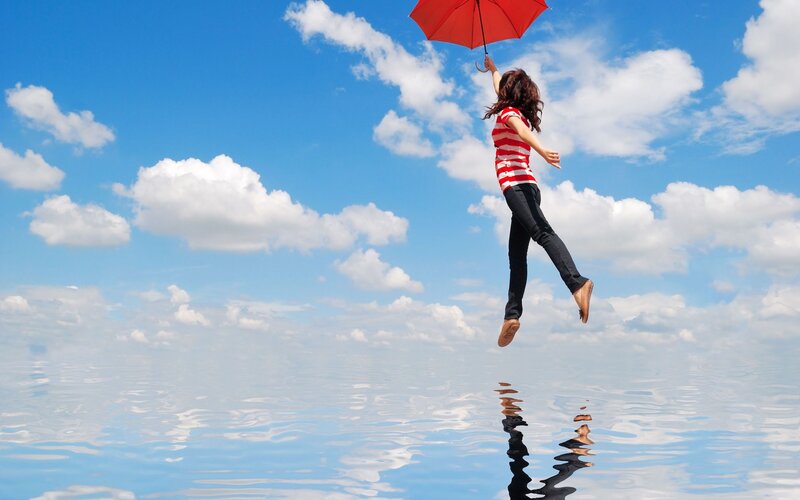Woman floating with red umbrella