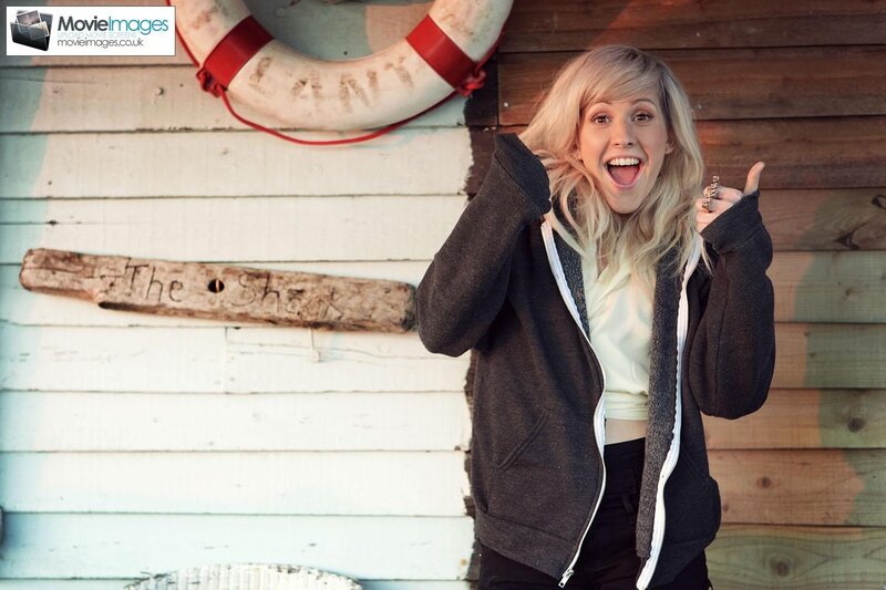 woman giving thumbs-up by shack