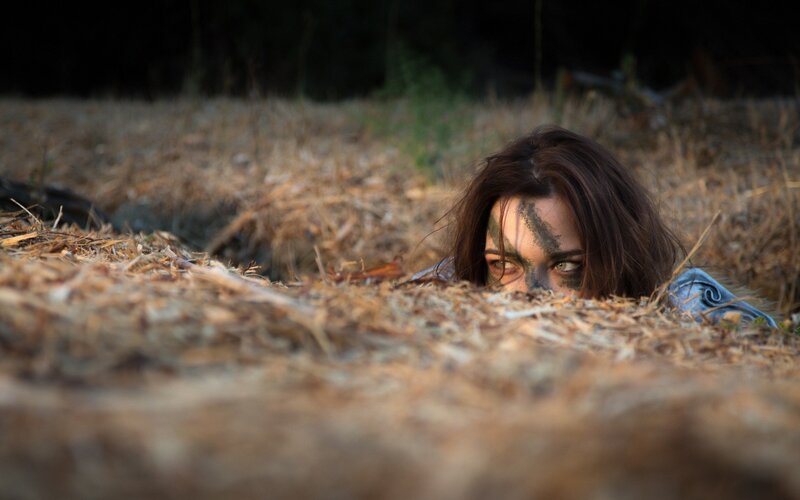 woman hiding in hay