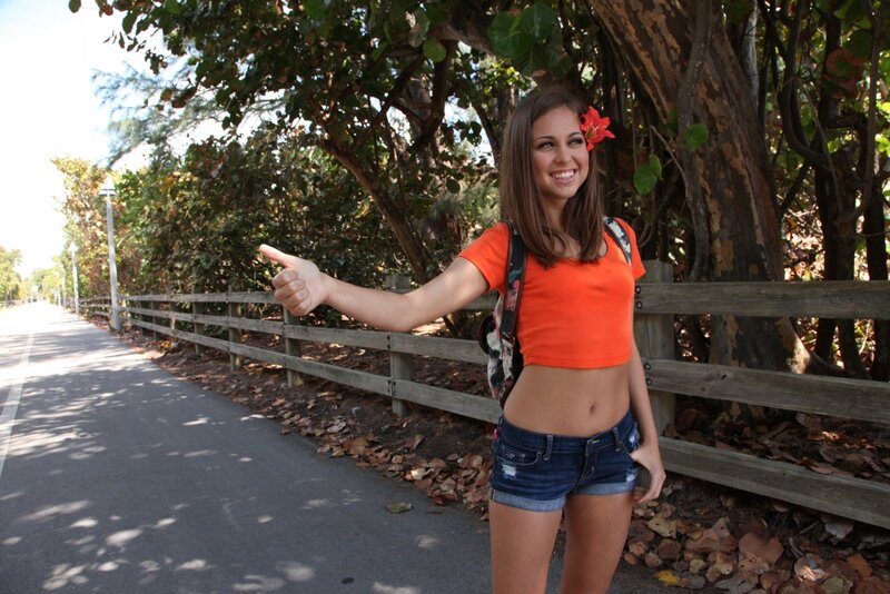 woman hitchhiking on a path