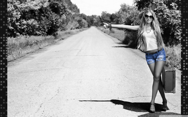 woman hitchhiking on a road