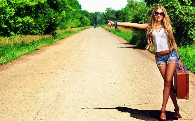 woman hitchhiking on country road