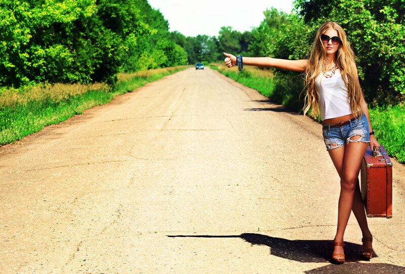 woman hitchhiking on country road