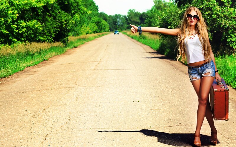 woman hitchhiking on country road