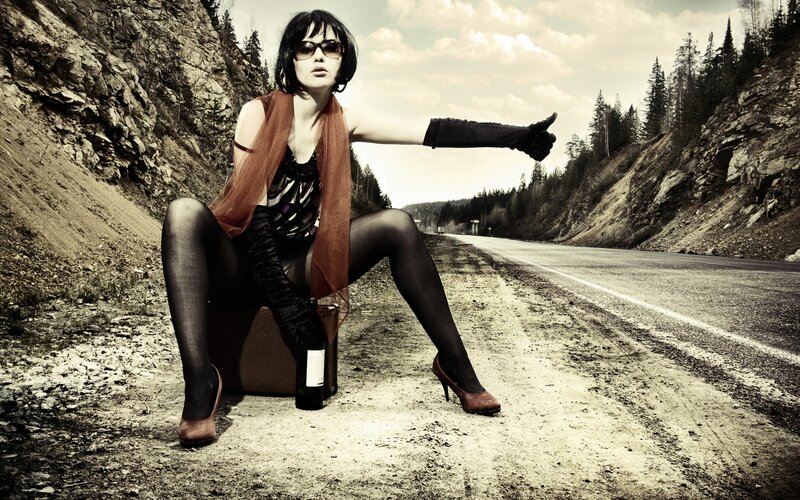 woman hitchhiking on road