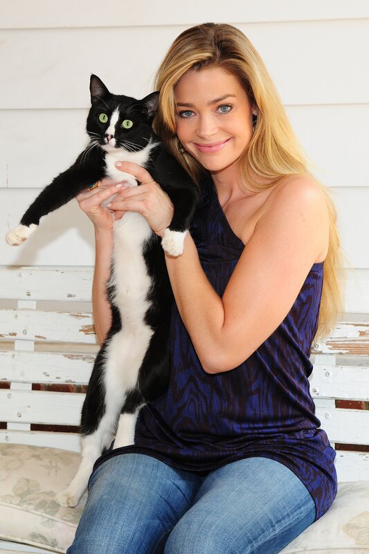 Woman holding a black and white cat