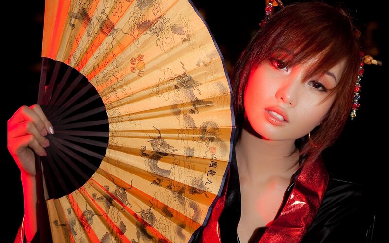 woman holding a dragon fan
