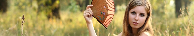woman holding a fan in a field