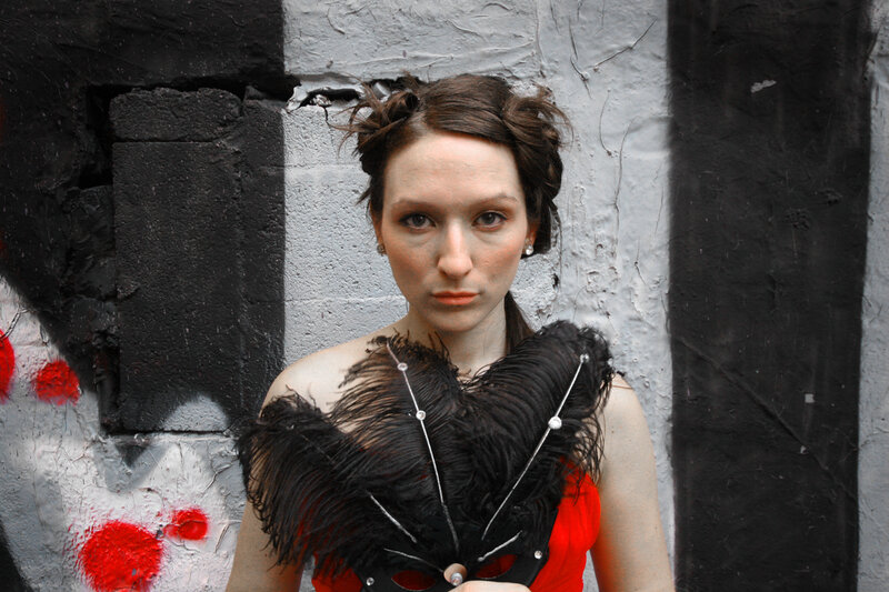 woman holding a feather mask