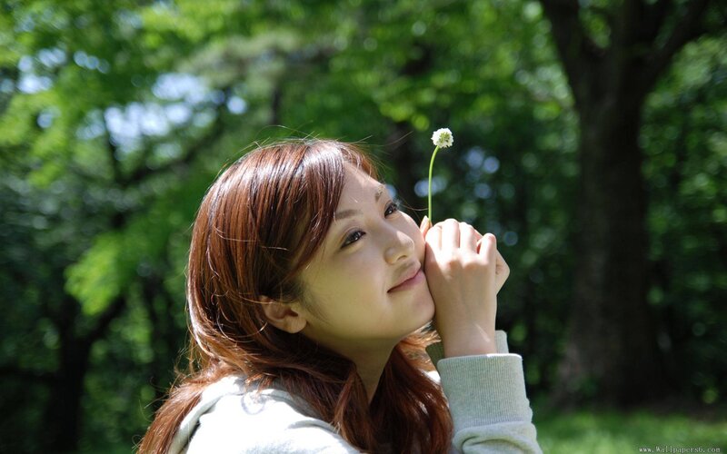 woman holding a flower in park