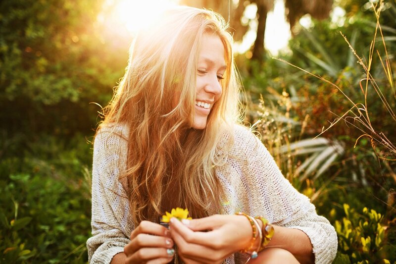 woman holding a flower in sunlight