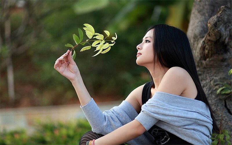 woman holding a leaf branch