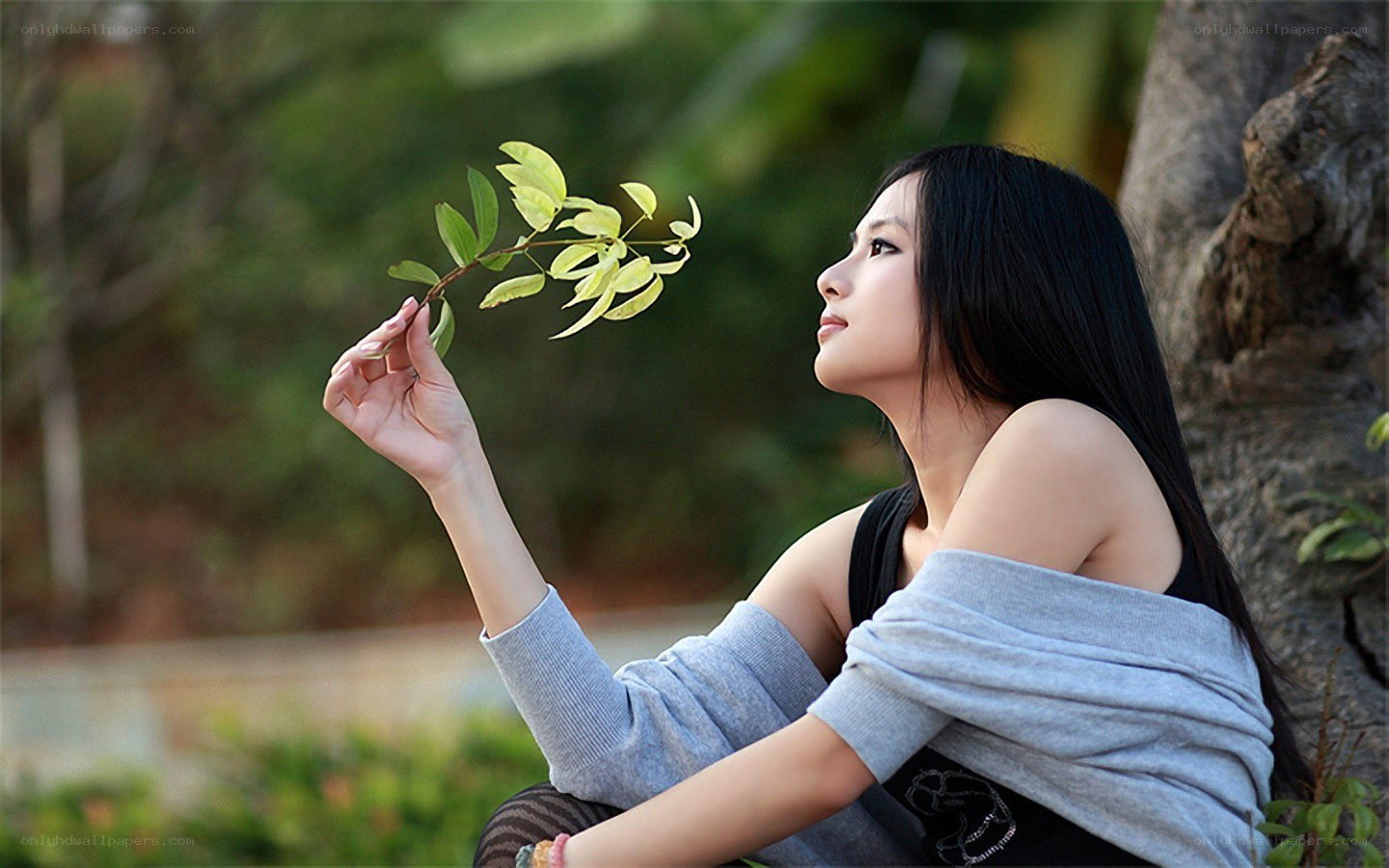 woman holding a leaf branch