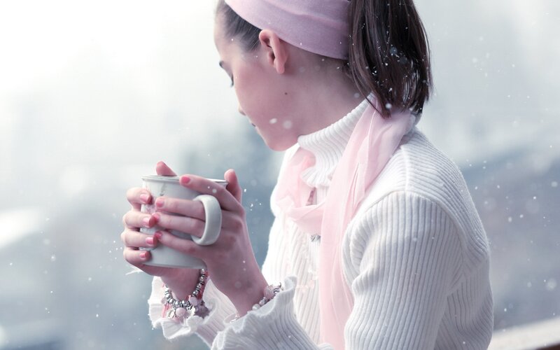 woman holding a mug in snow