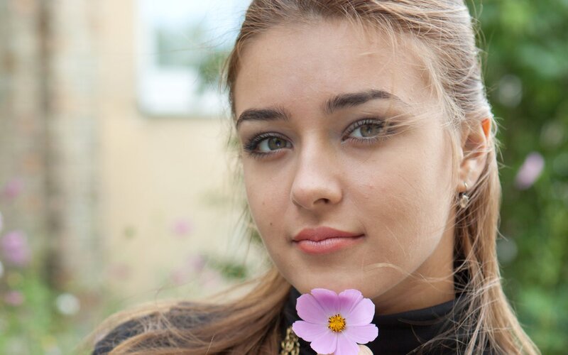 woman holding a pink flower