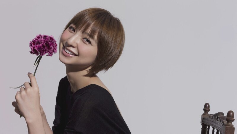 woman holding a purple flower