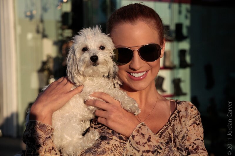 Woman holding a small white dog
