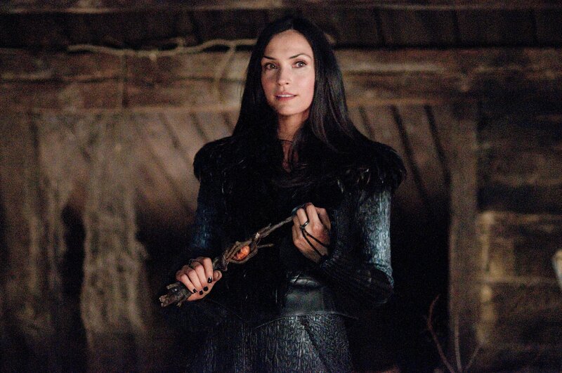 Woman holding a staff in a cave