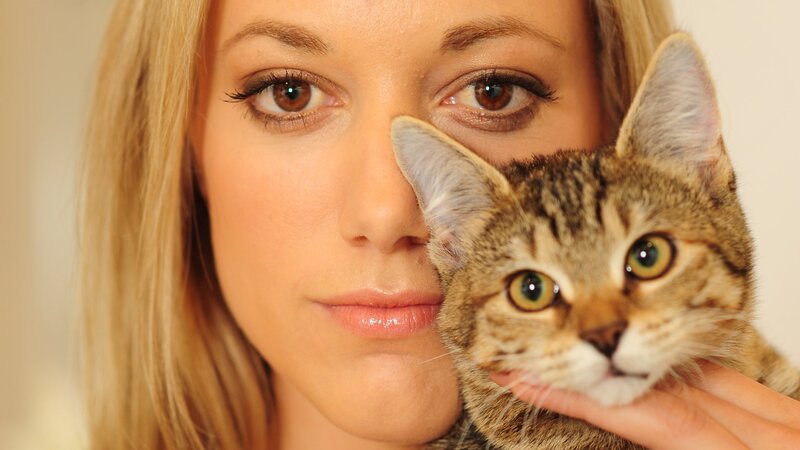 woman holding a tabby cat