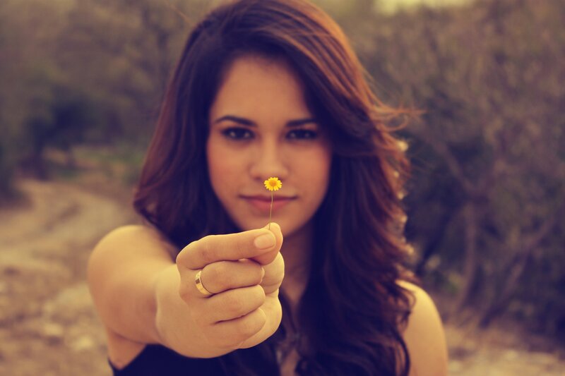 woman holding a yellow flower