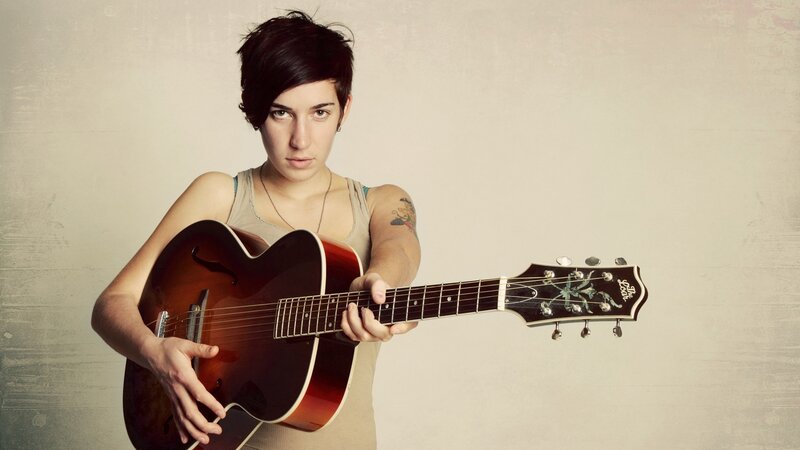 woman holding acoustic guitar