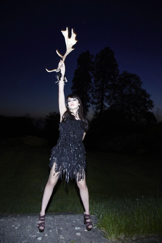 Woman holding antlers at night
