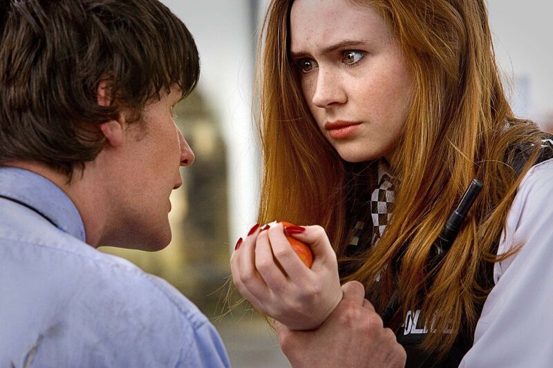 Woman holding apple to man
