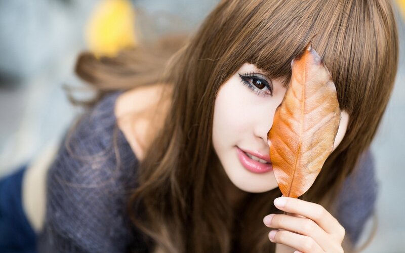 woman holding autumn leaf