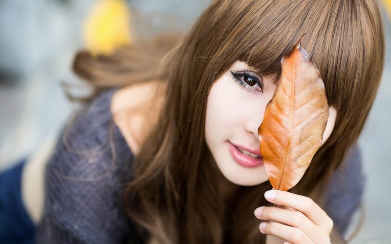 woman holding autumn leaf